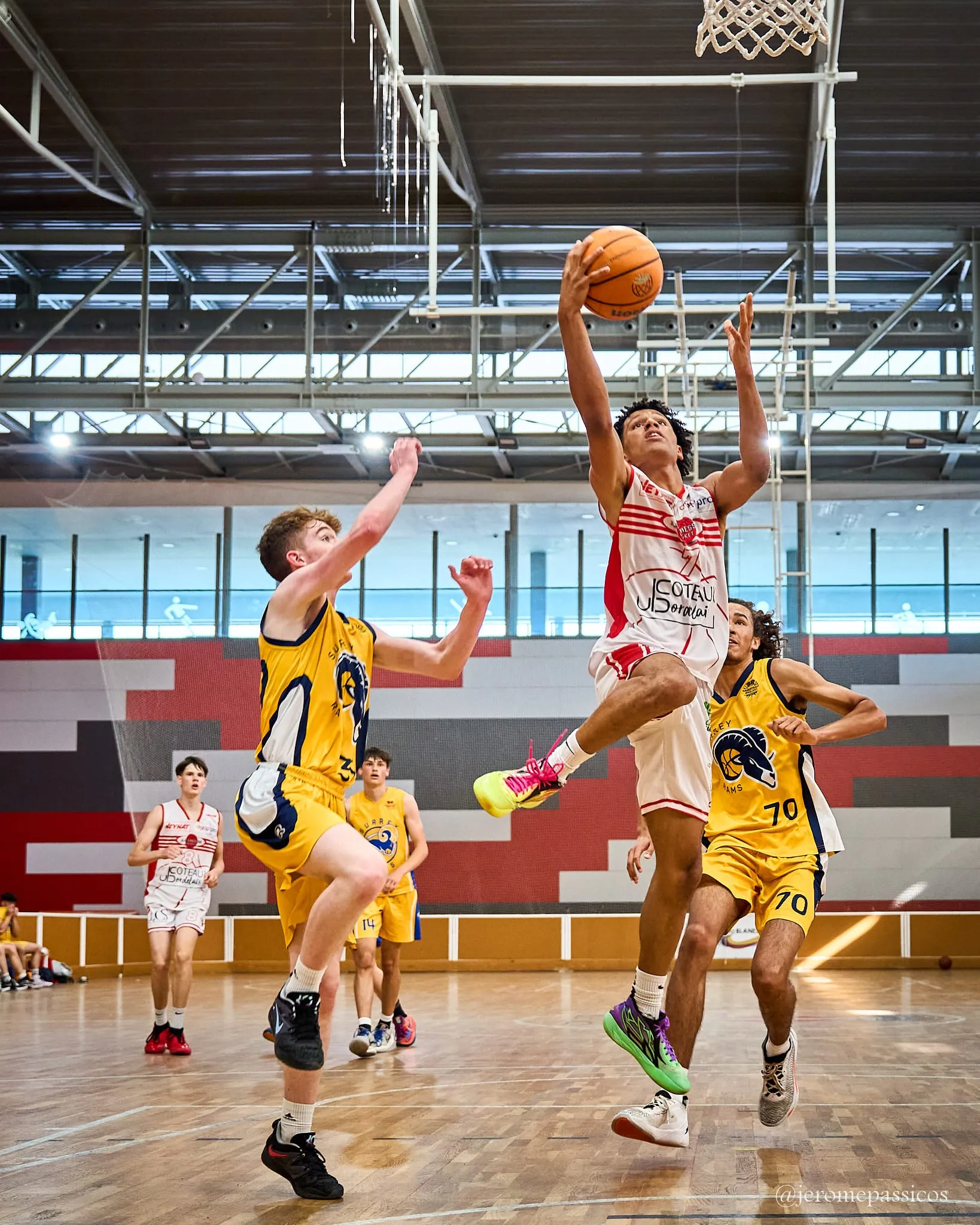 A player rising to the basket past two defenders