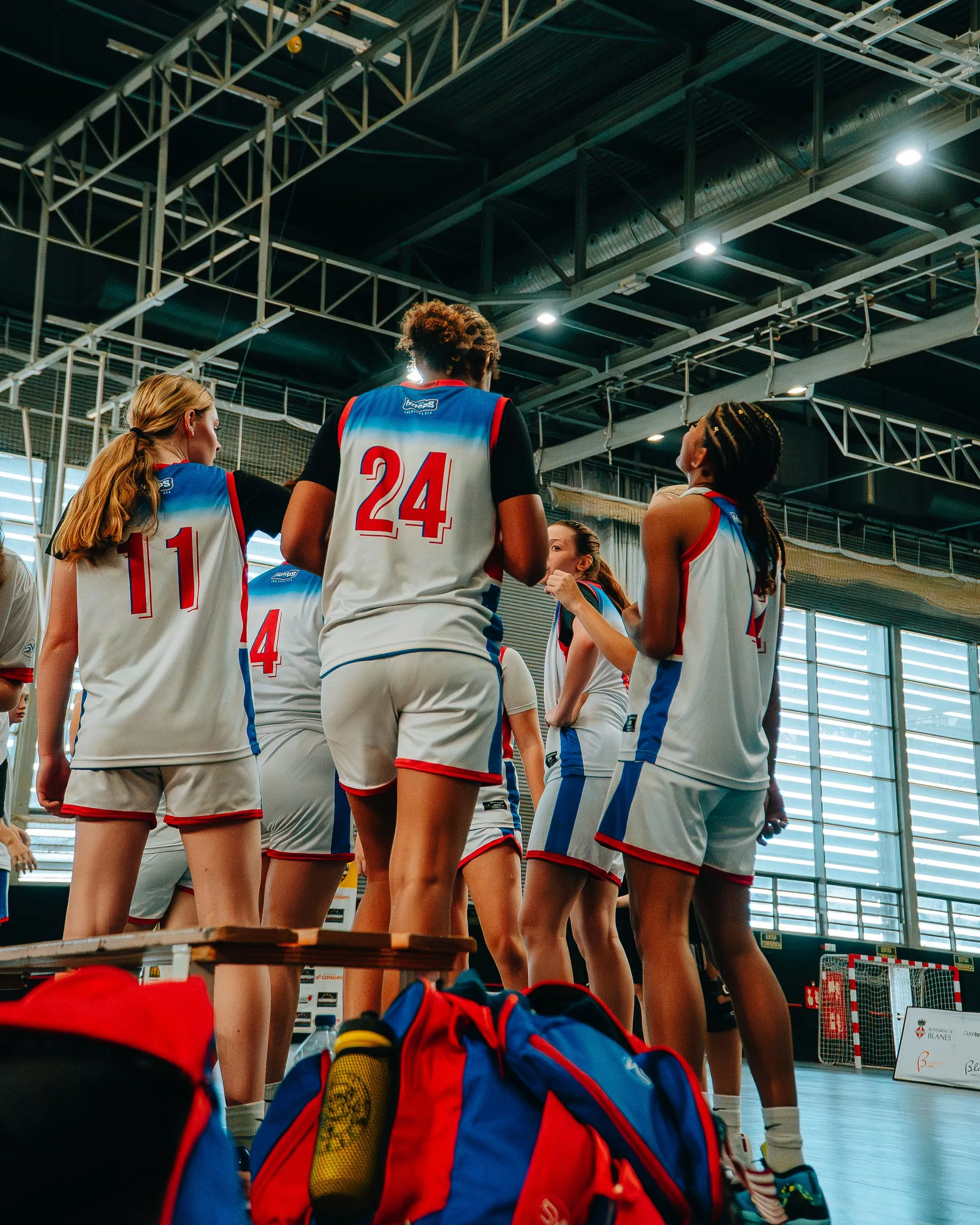 Players gathered with their kit bags at the side of the court