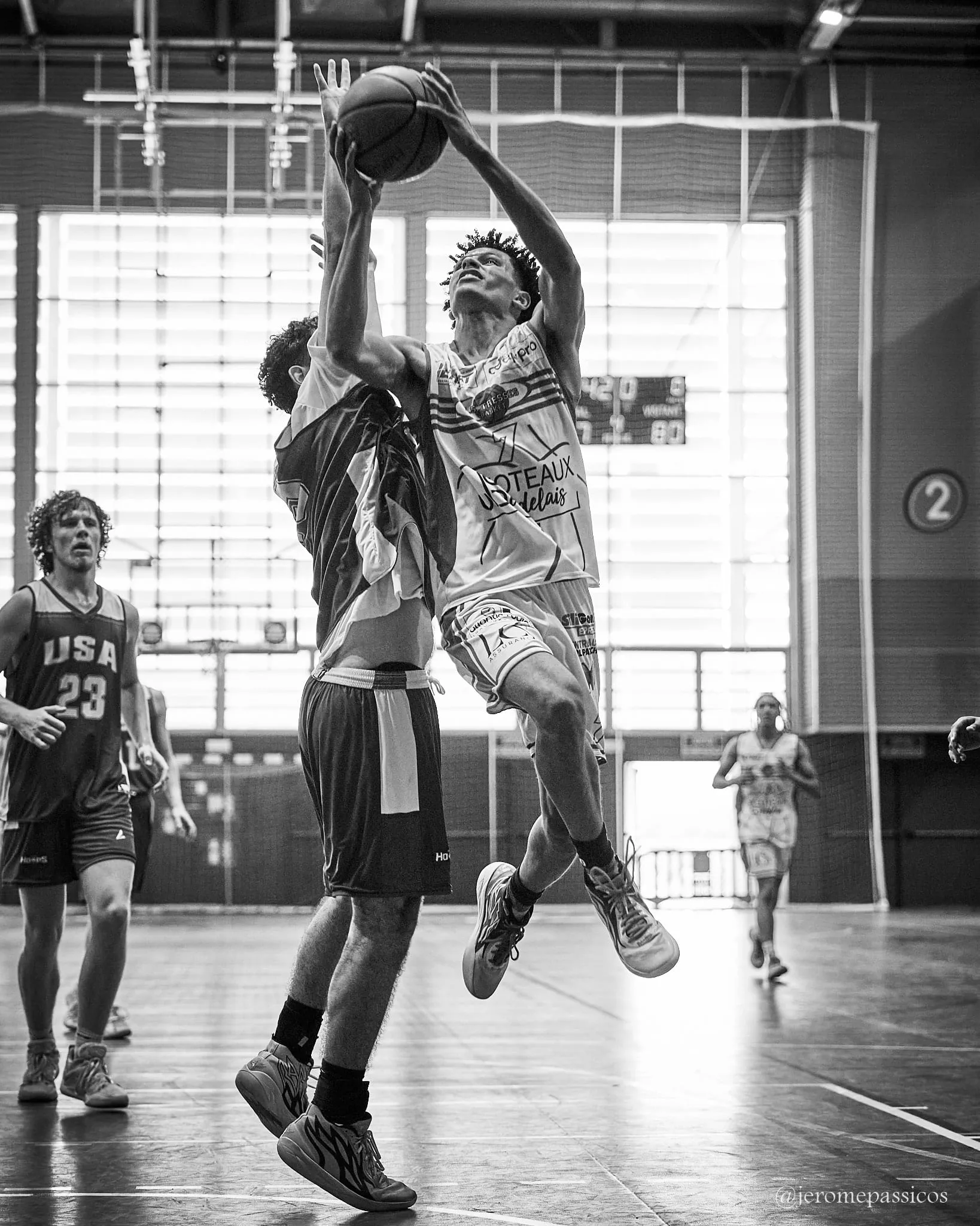 A player going up for a shot with a defender behind him