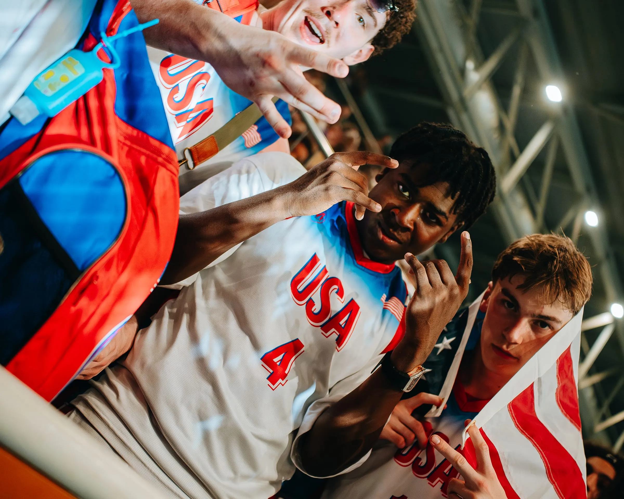 Players celebrating close to the camera, one holding a United States flag
