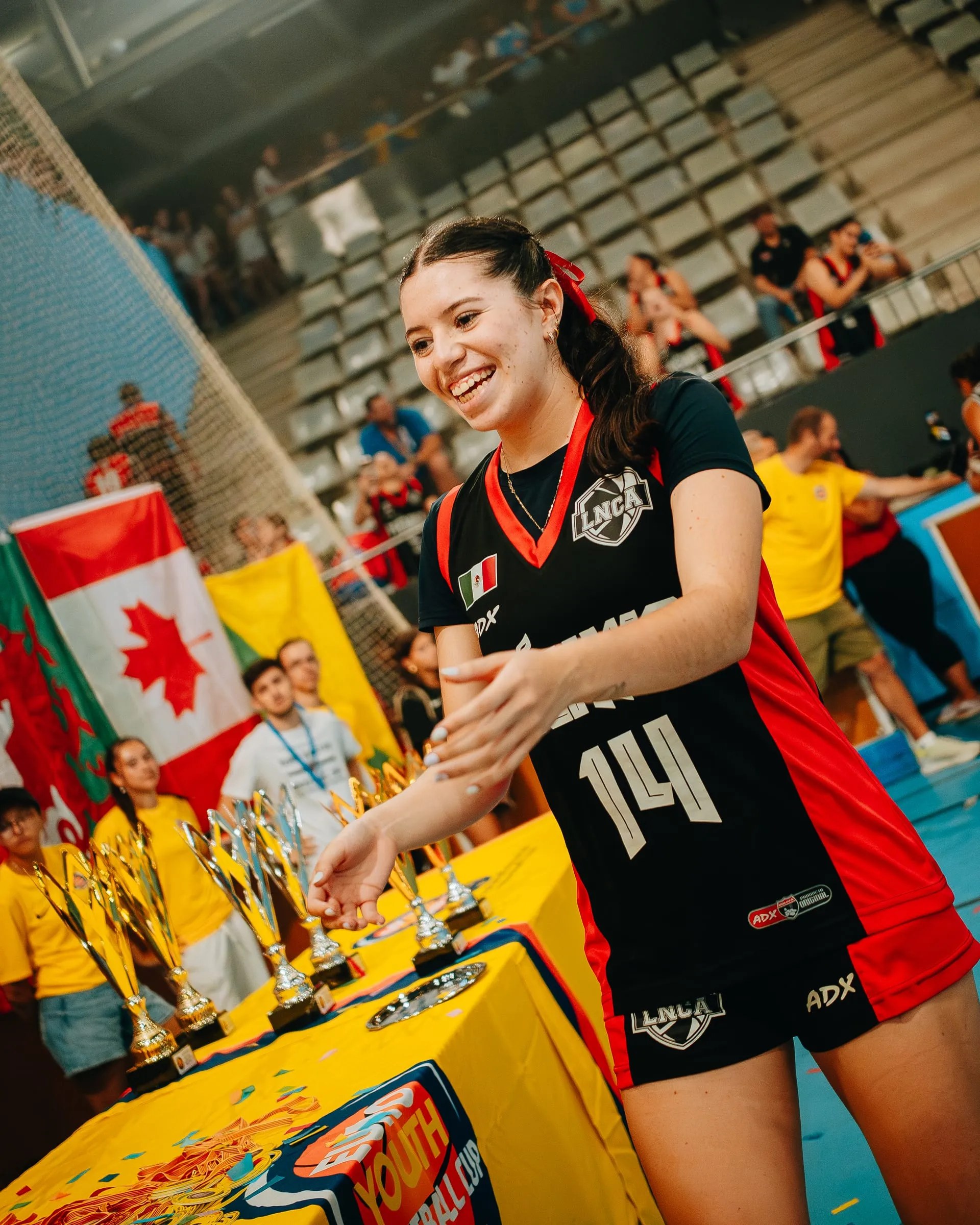 A player smiling beside the table of trophies
