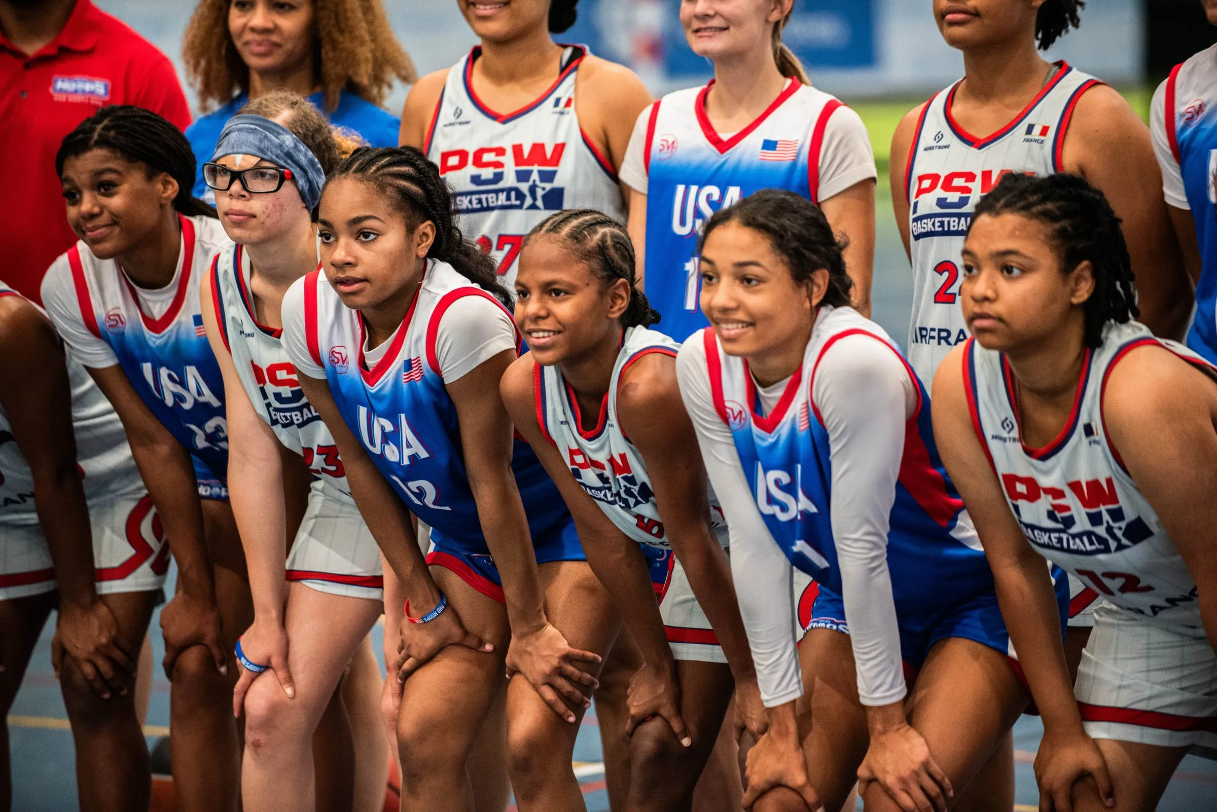 A girls' team lined up along the court before their game