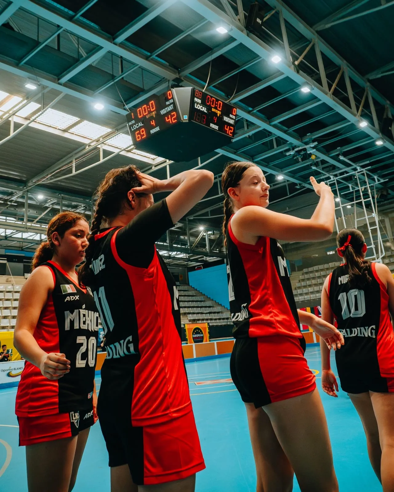 Players celebrating in front of the scoreboard at the final buzzer